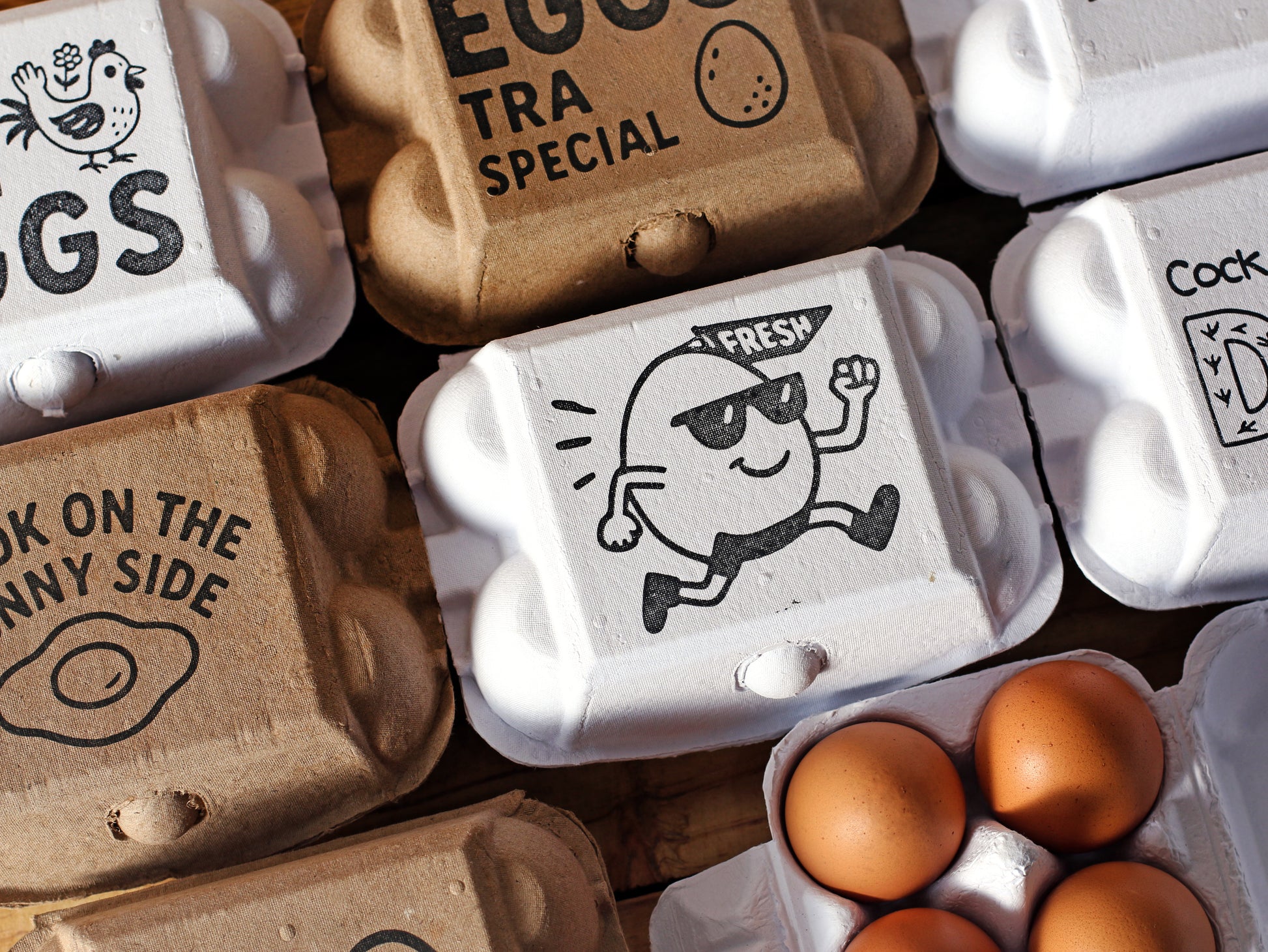 assorted egg cartons stamped with logo illustrations and wording; white and kraft pulp; various sizes; example branding set.