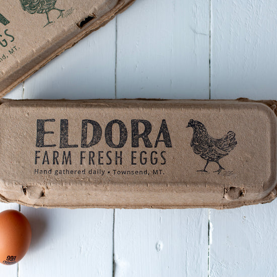wide lid branding stamp on kraft egg carton; black ink wordmark with chicken icon; product label placement across top.